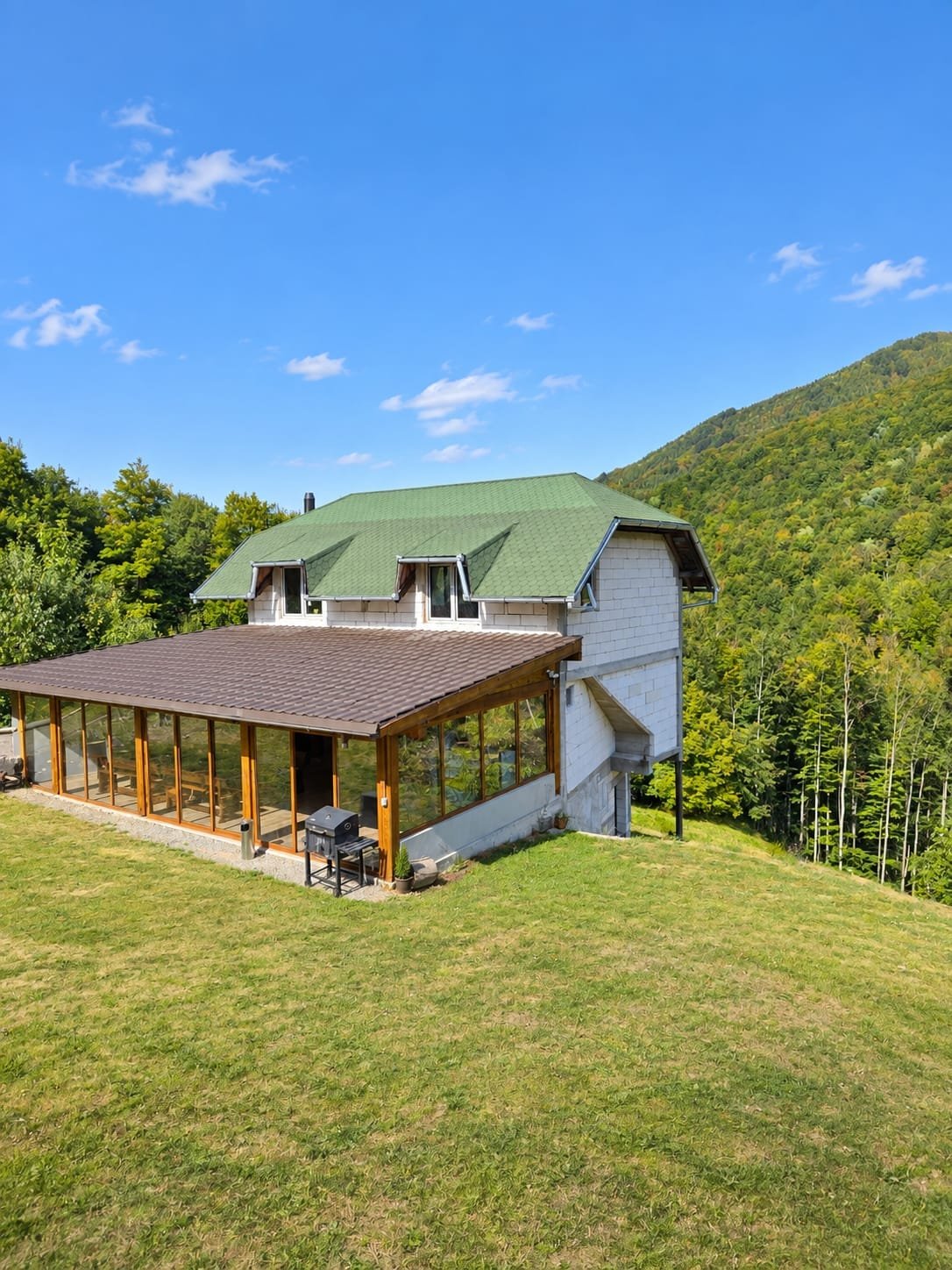 Cabana Marama vara, cu foișorul panoramic închis cu geamuri și gazonul întins